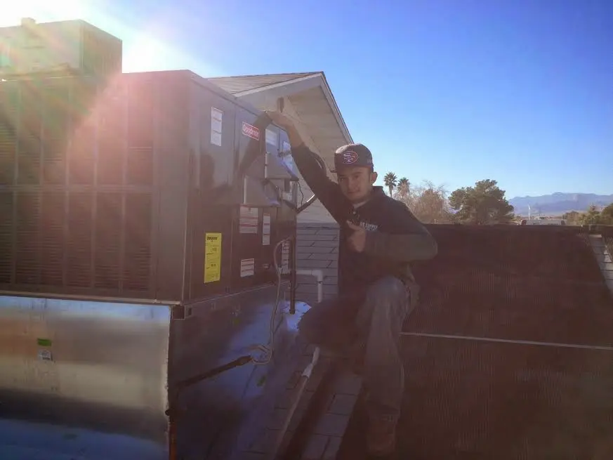 HVAC technician performing Heat Pump Repair on a rooftop unit in Avon